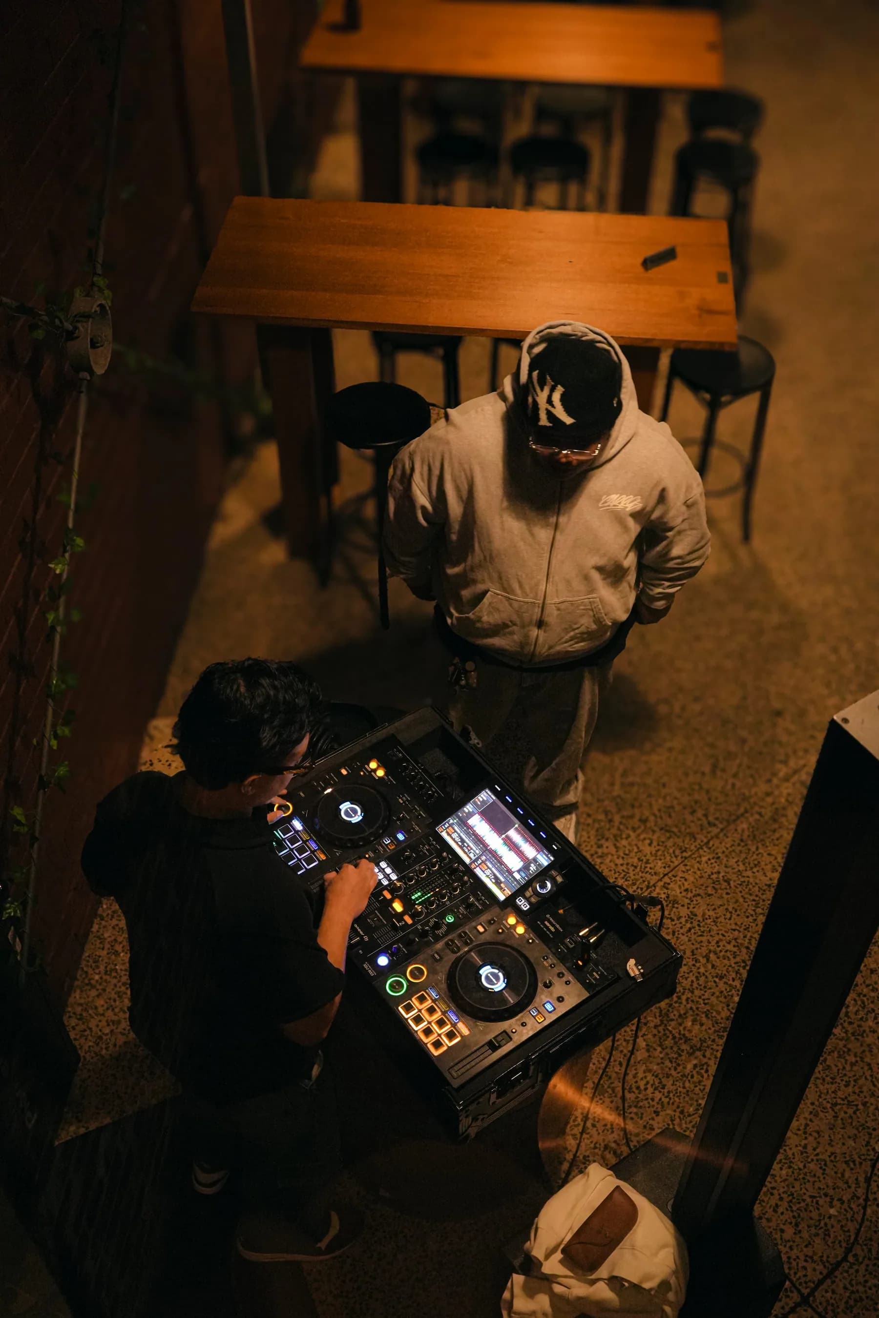 Sikuya performing behind the decks in a warm venue